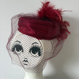 Claret satin vintage pillbox hat with mesh veil and feather trim