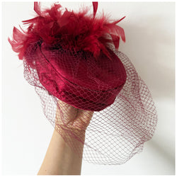 Claret satin vintage pillbox hat with mesh veil and feather trim